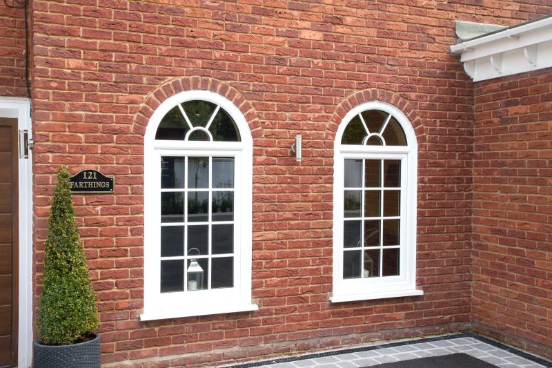 Traditional casement windows with arch top in brick building