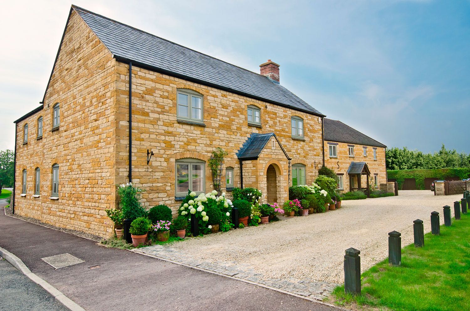 large country home with gravel driveway and green framed casement windows Redditch