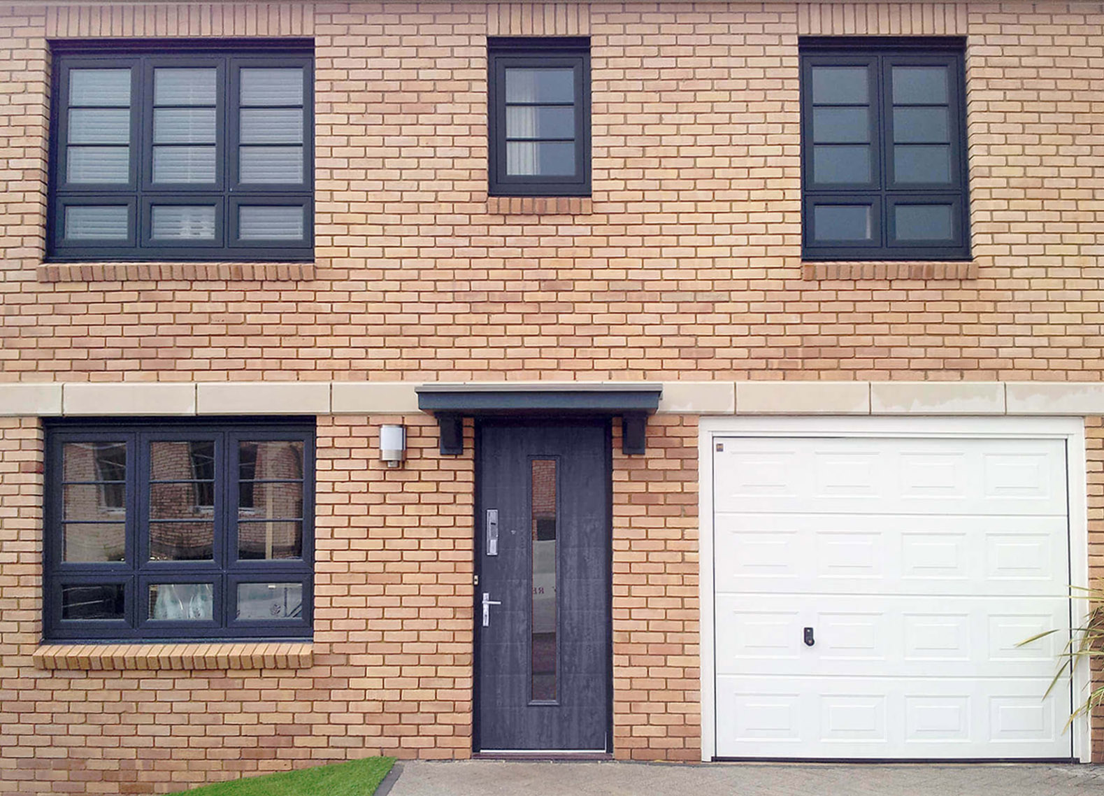 image of the front of a house with black casement windows Redditch and a garage